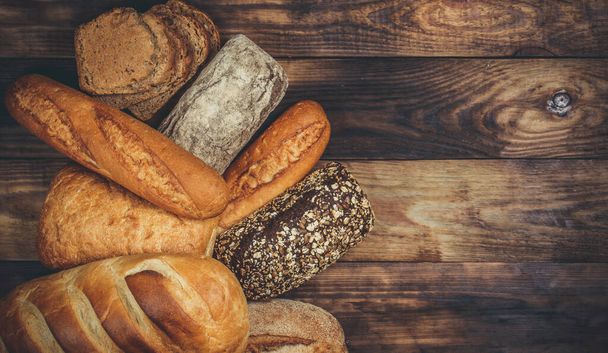 Різні хліби хліба і рулони з пшеницею і борошном на дерев'яному столі
 - Фото, зображення