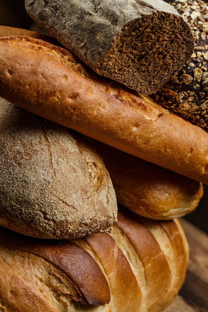 Diferentes pães e pães com trigo e farinha em uma mesa de madeira
 - Foto, Imagem