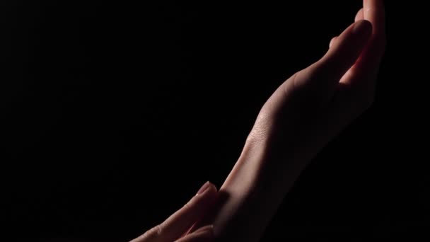 Gentle female hands on black background - Footage, Video