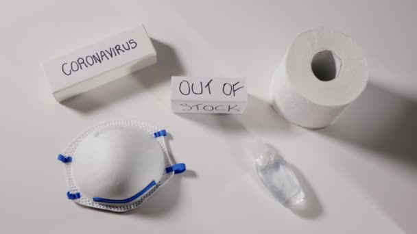 Coronavirus essentiels hors stock concept, pénurie mondiale sur les nécessités de base, masques personnels, désinfectant pour les mains et le papier toilette, coronavirus et le texte en rupture de stock sur la couche blanche, vue du dessus
 - Séquence, vidéo