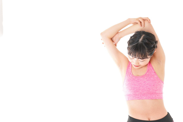 portrait of sporty Asian woman stretching over white background  - Photo, Image