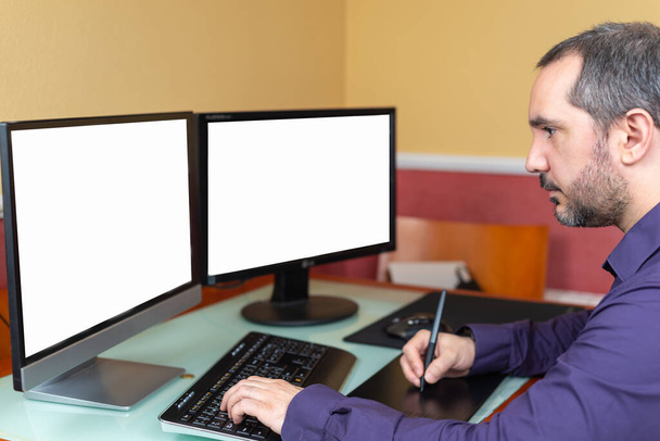 férfi teleworking a házban két képernyővel - Fotó, kép
