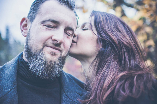 Close up photo of happy couple - brunette attractive woman and with stylish hairdo and beard man. Outdoor - Fotoğraf, Görsel