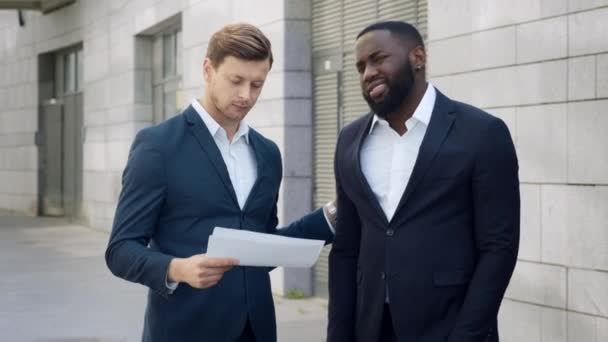 Upset businessmen looking bad work results on documents outdoors - Footage, Video