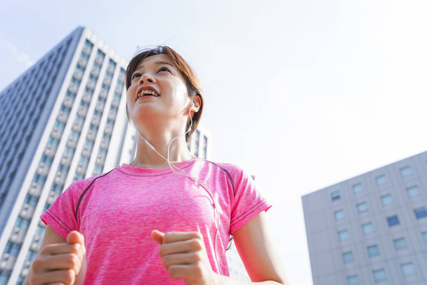 portrait of sporty Asian woman jogging in the city - Fotó, kép