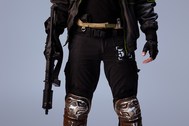 vista cortada do jogador cyberpunk segurando arma enquanto estava isolado em cinza
   - Foto, Imagem