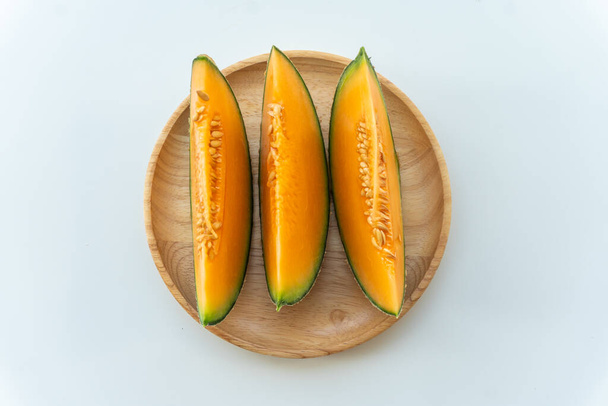 Fresh melons sliced on wooden plate on white background - Photo, Image