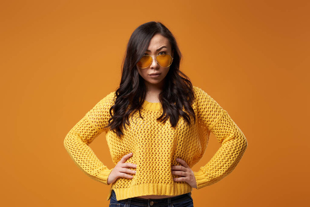 Serious oriental girl in yellow glasses in studio - Foto, Imagem