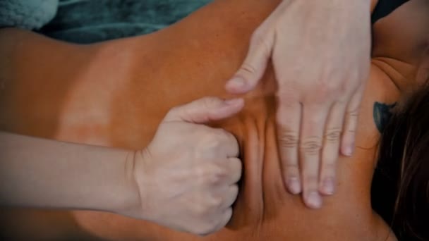 Massaggio - il massaggiatore sta impastando la pelle abbronzata sulla schiena del cliente con palmo e pugno
 - Filmati, video