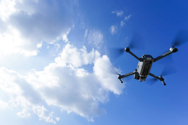 летающий дрон против голубого неба - Фото, изображение