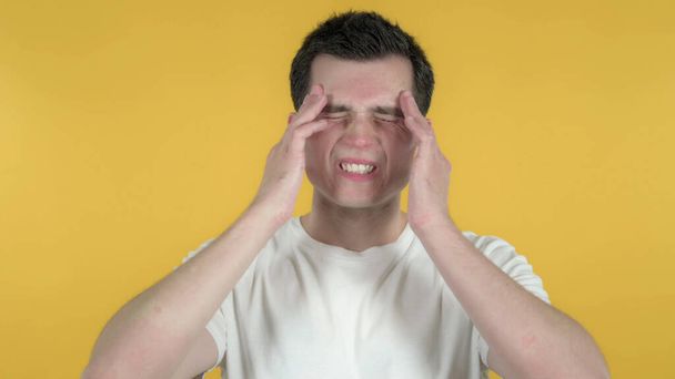 Homme occasionnel avec mal de tête isolé sur fond jaune
 - Photo, image