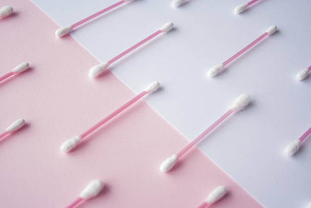 Flat lay cotton buds on pink warm and blue background. Pattern of cotton swubs, beauty and health care concept. Cotton composition - Photo, image