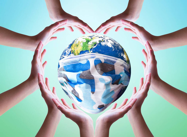 Earth Day concept: Heart shape of hands holding earth globe over blurred nature background.  - Valokuva, kuva