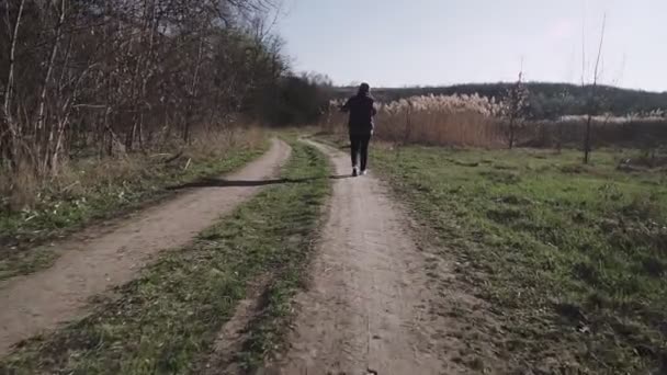 Uma jovem está andando ao longo de uma estrada rural e falando ao telefone
 - Filmagem, Vídeo