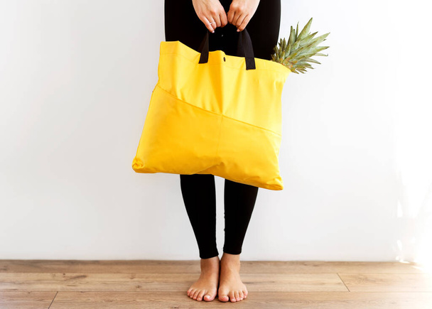 girl with a shopping bag in yellow hands wit - Photo, Image