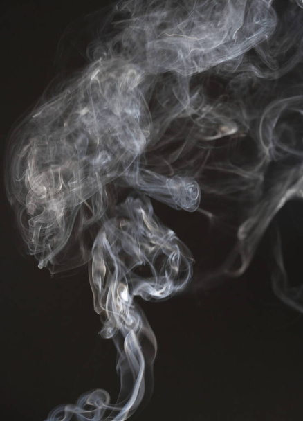 A fumaça branca se dissolve em um fundo isolado preto. Vapor ou nevoeiro no ar
 - Foto, Imagem