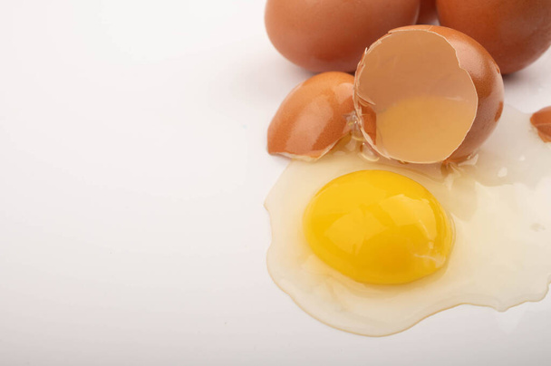 Ovo de frango quebrado e ovos espalhados em um fundo branco. Fechar
 - Foto, Imagem