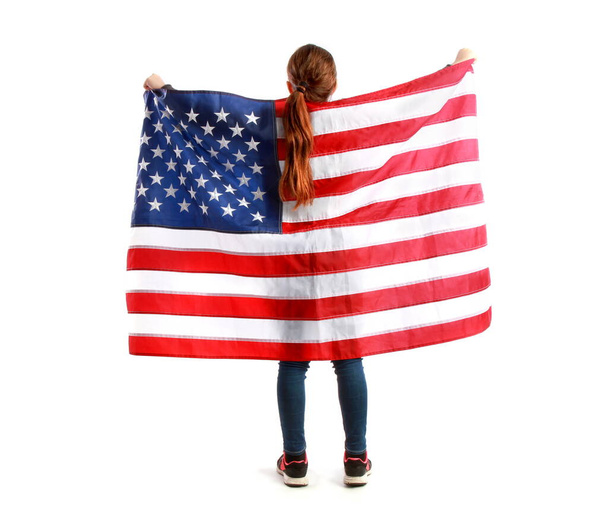 The little girl raised in outstretched arms behind her star-striped US flag. Isolated on a white background - Photo, Image