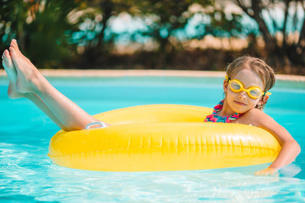 Adorable little girl swimming at outdoor swimming pool - Photo, Image