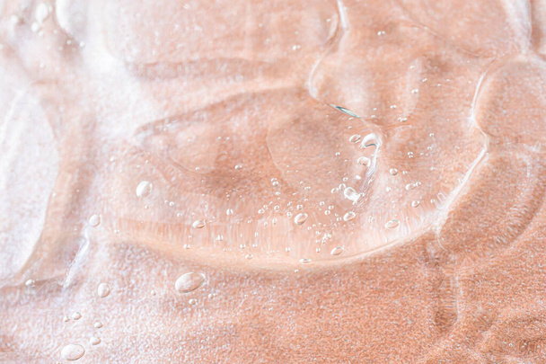 Gros plan sur gel cosmétique antibactérien transparent. Le concept de propreté. Antiseptique. Mère de fond rose perle
. - Photo, image