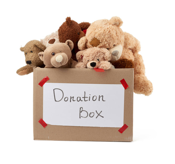 brown cardboard box filled with soft toys,inscription on the box, concept of charity and assistance to needy children - Photo, Image