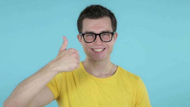 Casual Man Gesturing Thumbs Up Isolated on Blue Background - Photo, Image