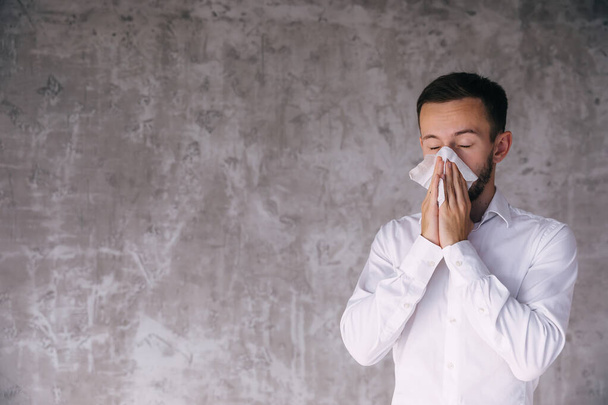 Infected man blows nose in tissue, has allergy symptoms during spring time, cannot breath well, sneezes constantly, cries as feels tired of treatment. Immunotherapy concept - Zdjęcie, obraz