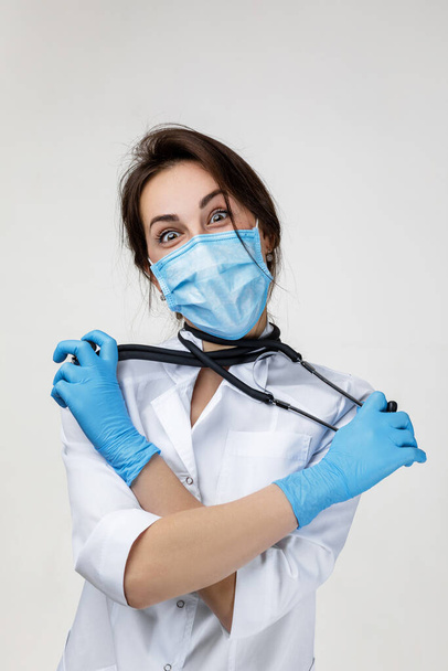 funny woman doc in white lab coat fooling around with a stethoscope - Zdjęcie, obraz