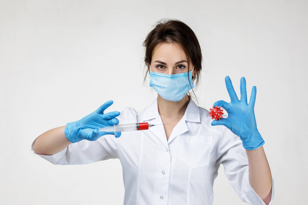 woman doctor holding syringe and virus model - Foto, imagen