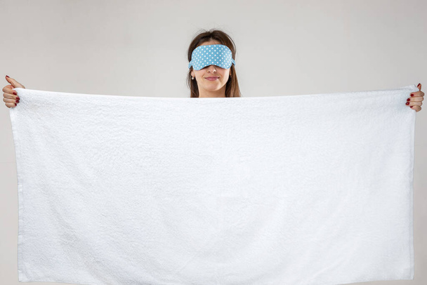 young caucasian woman in eyemask holding towel - Photo, Image