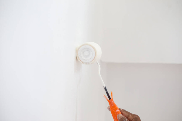 Malarz ręcznie malować biały kolor na ścianie wewnętrznej z rolki, Dom remontu - Zdjęcie, obraz