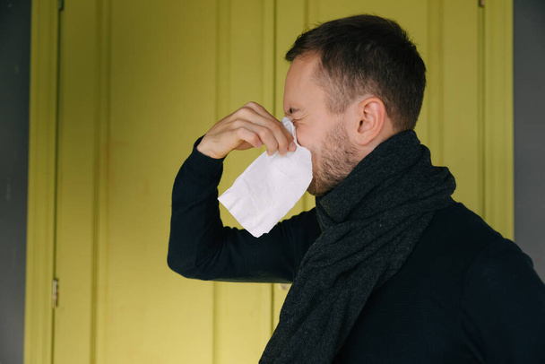 Molesto al hombre, sonándose la nariz, fiebre, resfriado, estornudos en el tejido, enfermo con síntomas de coronavirus, concepto de gripe - Foto, Imagen