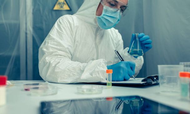Cientista com terno de proteção investigando no laboratório - Foto, Imagem
