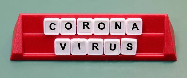 Κείμενο Coronavirus κατασκευασμένο με πλαστικά γράμματα σε ένα lectern κατά τη διάρκεια του επιτραπέζιου παιχνιδιού - Φωτογραφία, εικόνα