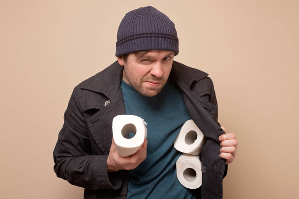 speculator man holding several roll of toilet paper. Do you want to buy it - Foto, Imagen