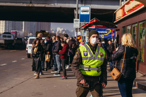 KYIV, UKRAINE - March 19. 2020. Quarantine in the city of Kiev due to the COVID-19 virus. People are standing at public transport stops in protective masks against the virus. - Photo, Image