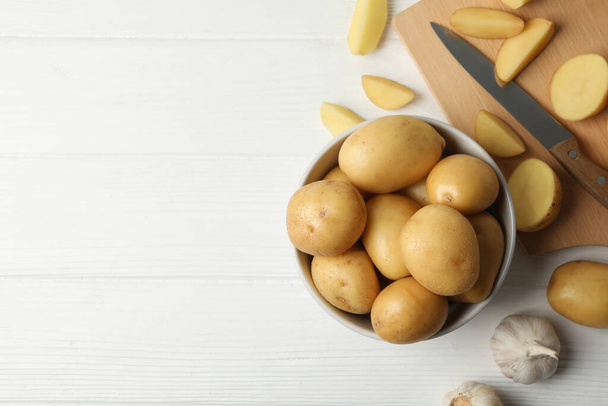 Bowl with young potato on wooden background, top view - Foto, Imagen