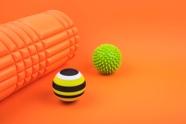 Set of two myofascial release and massage balls, bumpy foam massage roller for trigger points over orange background. - Photo, Image
