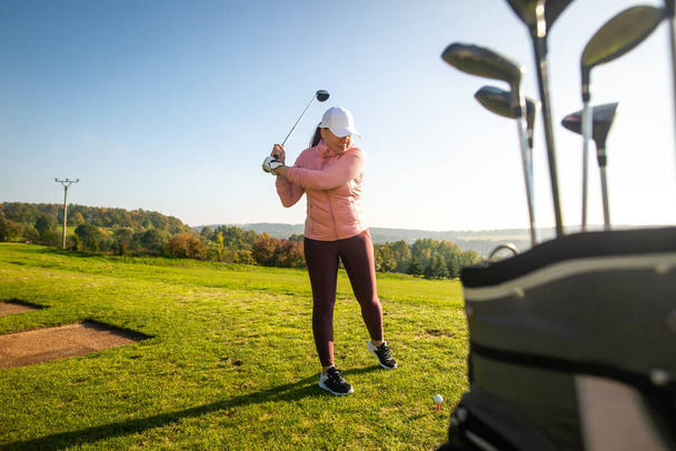 Żeński żebrak golfista gra w golfa na placu treningowym, koncepcja sportowa - Zdjęcie, obraz