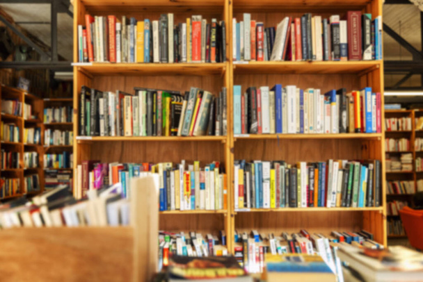 Könyvekkel teli polcok egy könyvesboltban. Oktatás és fejlesztés. Homályos. - Fotó, kép