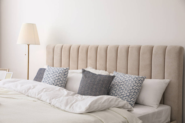 Comfortable bed with pillows in room. Stylish interior design - Φωτογραφία, εικόνα