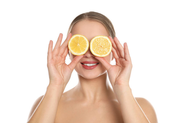 Young woman with cut lemon on white background. Vitamin rich food - Valokuva, kuva
