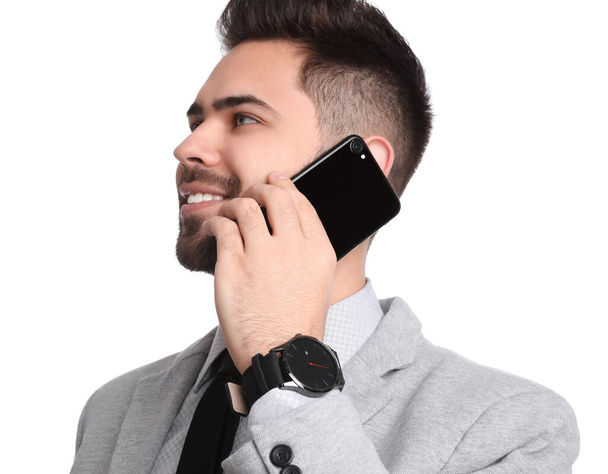 Young businessman talking on smartphone against white background - Photo, Image