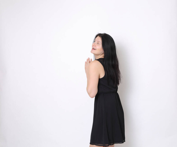 Biała kobieta w eleganckiej małej czarnej sukience / Radosna kobieta pozująca przed kamerą - Zdjęcie, obraz