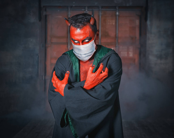 コロナウイルスのキャラクターに医療面マスクを身に着けている赤い鬼。流行病の流行 - 写真・画像