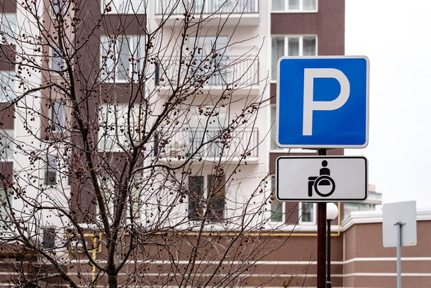 車いす利用者のための交通標識駐車場や補助区域内の障害者用ドライバー。青は白の文字で埋めます。障害者のための大文字Pと馬車記号 - 写真・画像