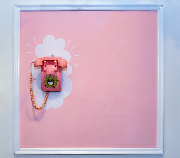 壁の古いピンクの電話 - 写真・画像