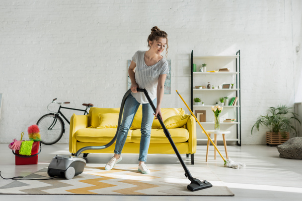 happy girl cleaning carpet with vacuum cleaner  - 写真・画像