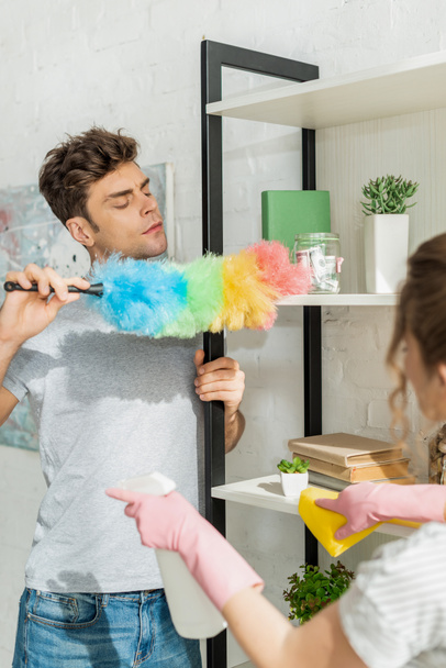 selective focus of handsome man cleaning shelve near girl  - Photo, Image