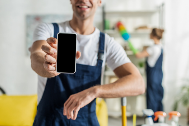 cropped view of happy cleaner holding smartphone with blank screen  - Photo, image